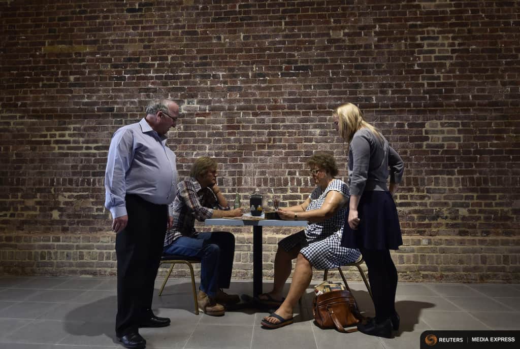 Visitors (L and R) view a sculpture entitled 'Self-Portrait and Model' by the late U.S. artist Duane Hanson is exhibited at the Serpentine Sackler Gallery in London, June 1, 2015. Hanson's lifelike sculptures portraying working-class Americans and overlooked members of society are being brought together in the largest show of his work in Britain since 1997. REUTERS/Toby Melville